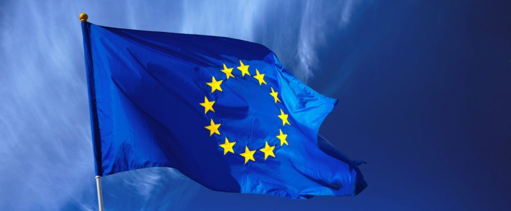 The European Union flag flying against a blue sky